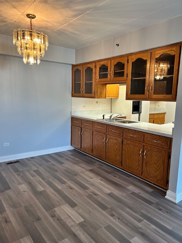 kitchen featuring decorative light fixtures, sink, backsplash, and dark hardwood / wood-style floors