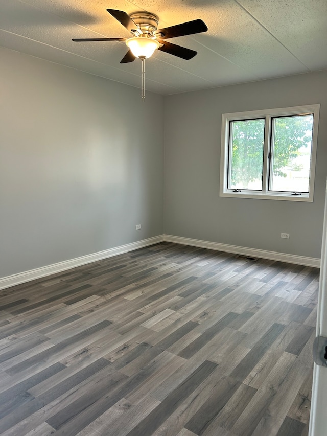 unfurnished room with ceiling fan, dark hardwood / wood-style flooring, and a textured ceiling