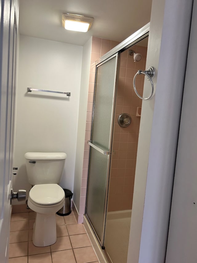 bathroom with walk in shower, tile flooring, and toilet