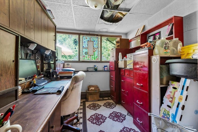 home office with light floors and a paneled ceiling