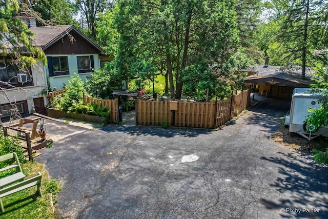 view of yard featuring cooling unit, fence, and driveway