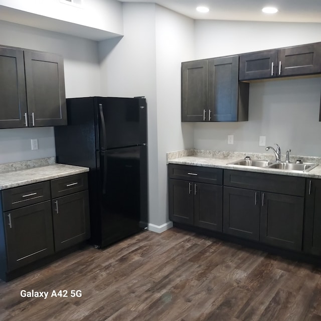 kitchen with dark wood finished floors, recessed lighting, freestanding refrigerator, vaulted ceiling, and a sink