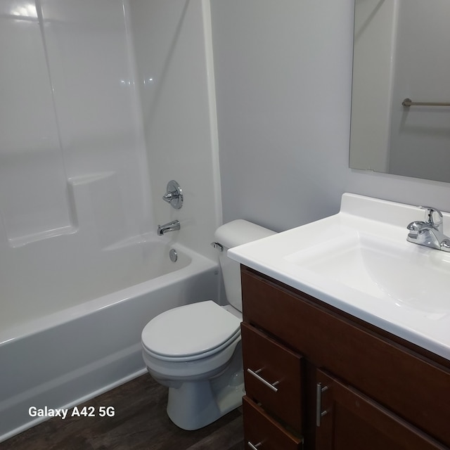 full bath with toilet, shower / bathing tub combination, wood finished floors, and vanity