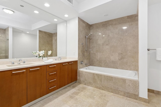 bathroom with tiled shower / bath combo and vanity