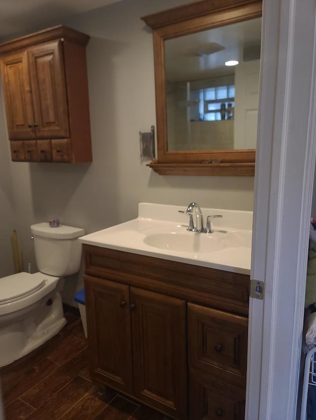 bathroom with wood-type flooring, toilet, and vanity