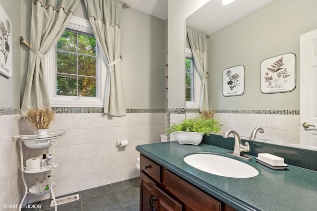 bathroom with vanity, tile walls, toilet, and tile patterned floors