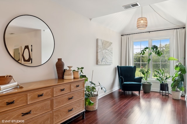 living area with dark wood-type flooring, a chandelier, and vaulted ceiling