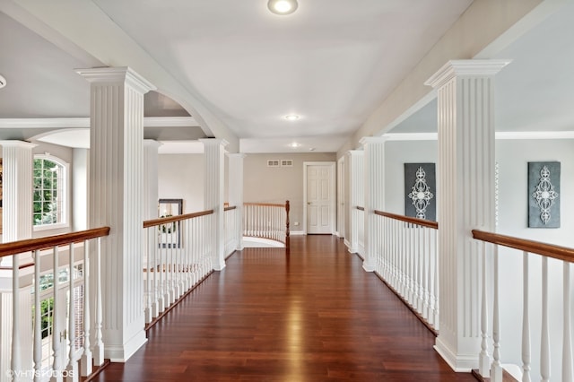 corridor featuring ornamental molding, dark hardwood / wood-style floors, and ornate columns