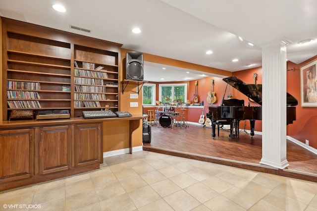 office space featuring light wood-type flooring and ornate columns