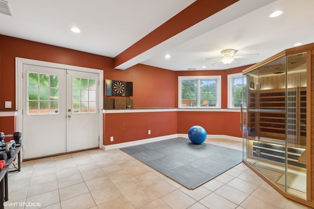 workout area featuring ceiling fan, light tile patterned floors, and french doors