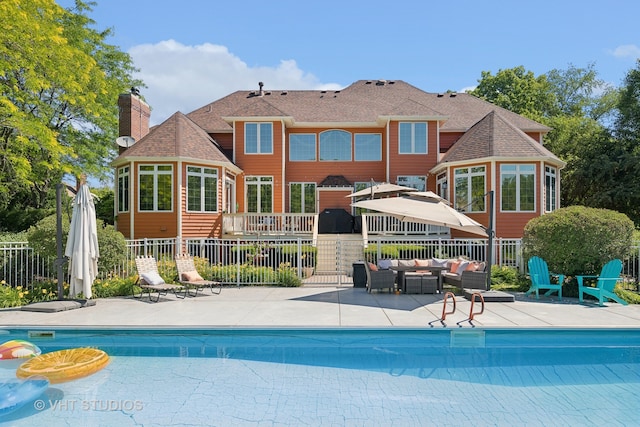 rear view of house with a fenced in pool, an outdoor hangout area, and a patio