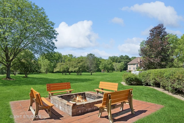 wooden deck featuring a lawn, a patio area, and an outdoor fire pit