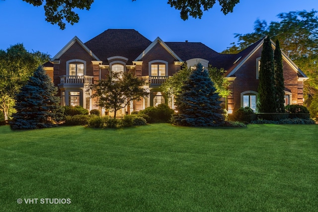 french country home with a balcony and a front yard