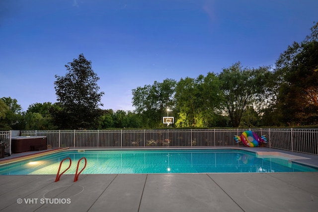 pool at dusk featuring a patio