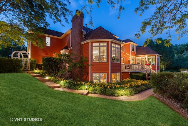 rear view of property with a lawn and a wooden deck