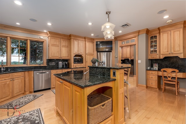 kitchen featuring a center island, hanging light fixtures, appliances with stainless steel finishes, dark stone counters, and backsplash