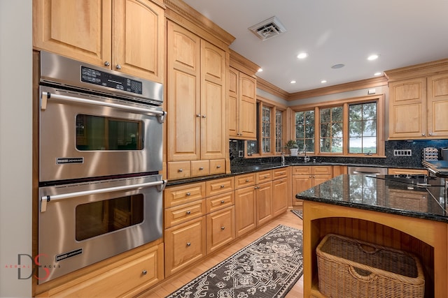 kitchen featuring crown molding, dark stone counters, backsplash, and stainless steel appliances