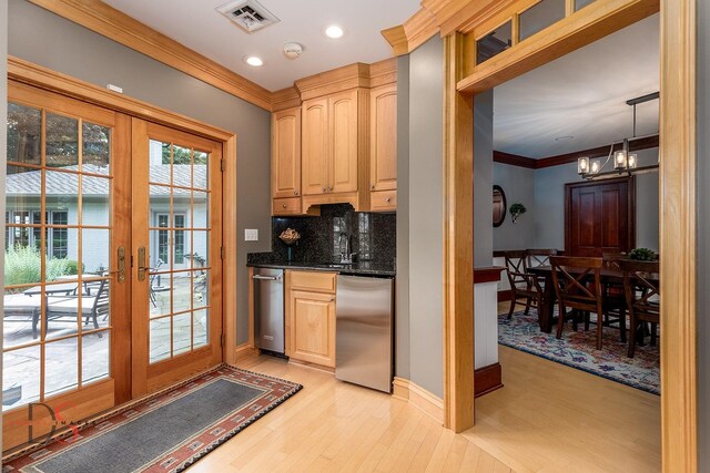 kitchen with dishwasher, hanging light fixtures, light hardwood / wood-style flooring, and backsplash