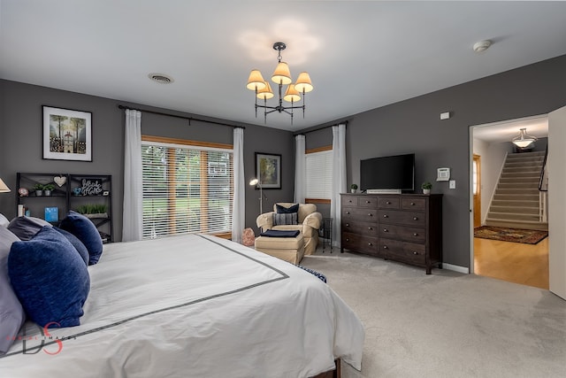 bedroom with an inviting chandelier and light colored carpet