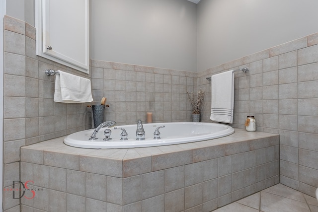 bathroom with tile flooring, tiled tub, and tile walls