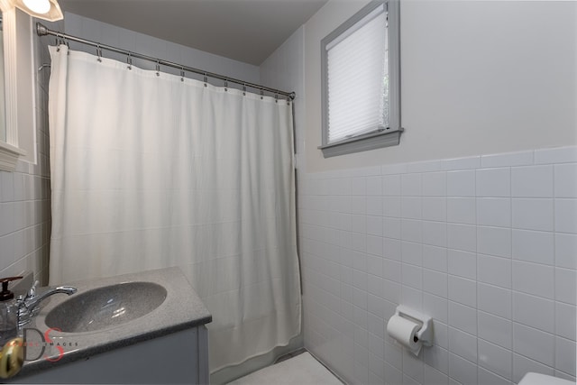 bathroom featuring vanity and tile walls