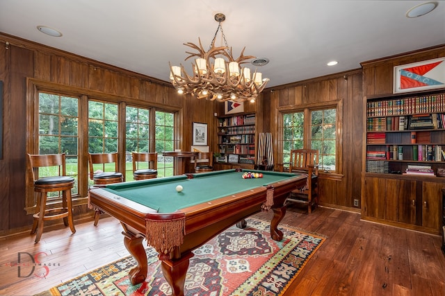 rec room with an inviting chandelier, dark hardwood / wood-style flooring, billiards, crown molding, and wooden walls