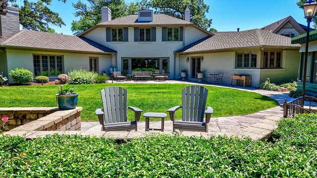 back of property featuring a patio and a lawn