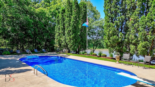 view of swimming pool featuring a diving board and a patio area