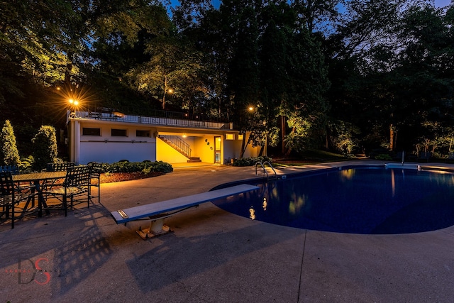 view of swimming pool featuring a diving board and a patio area