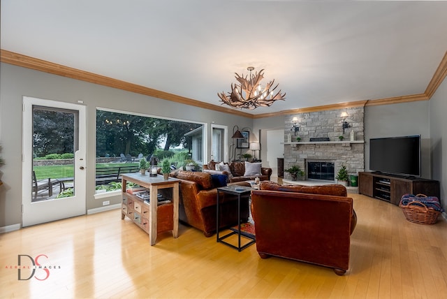 living room featuring a stone fireplace, a chandelier, ornamental molding, and light wood-type flooring