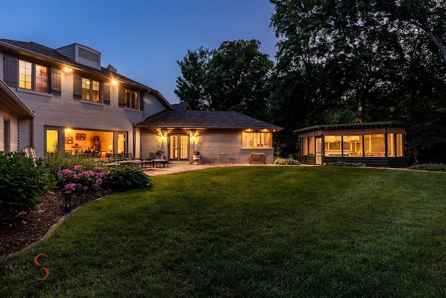 rear view of house featuring a yard