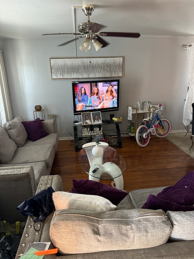 living room featuring ceiling fan and dark hardwood / wood-style flooring