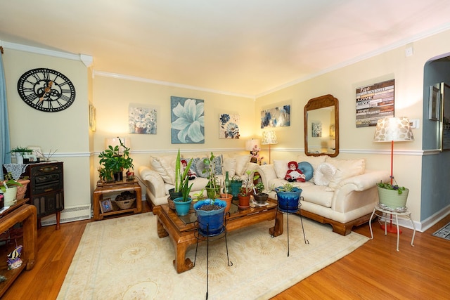 living room with wood-type flooring, baseboard heating, and crown molding