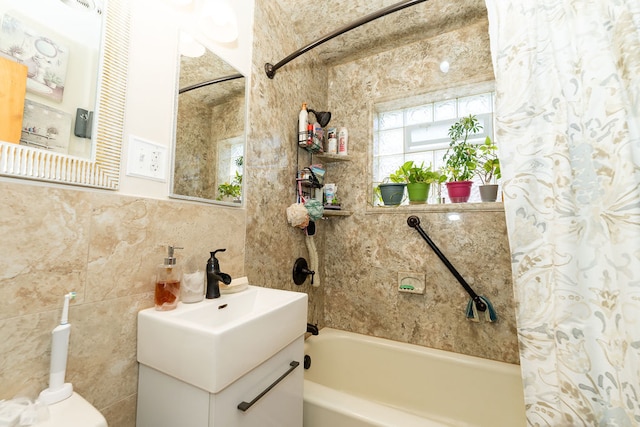 bathroom with vanity, tile walls, and shower / tub combo