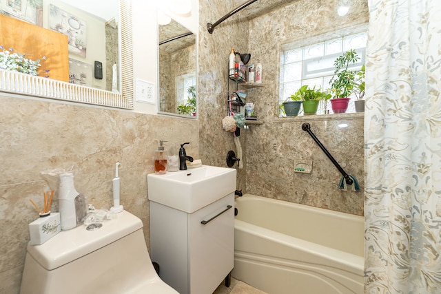 full bathroom with vanity, toilet, tile walls, and shower / tub combo