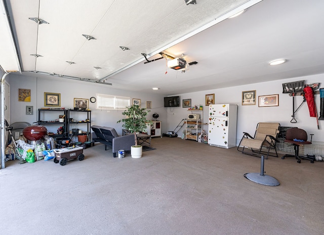 garage with a garage door opener and white fridge