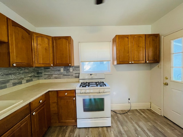 kitchen featuring a healthy amount of sunlight, wood-type flooring, and white range with gas stovetop