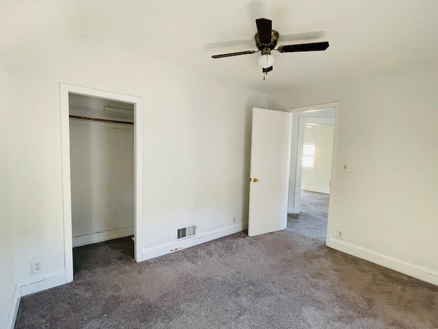 unfurnished bedroom with a closet, ceiling fan, and dark colored carpet