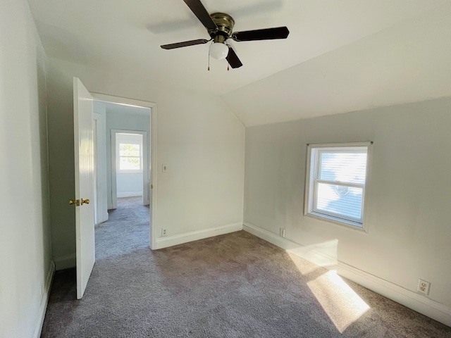 additional living space with lofted ceiling, carpet, a healthy amount of sunlight, and ceiling fan