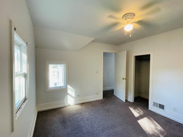 unfurnished bedroom featuring a closet, ceiling fan, and dark colored carpet