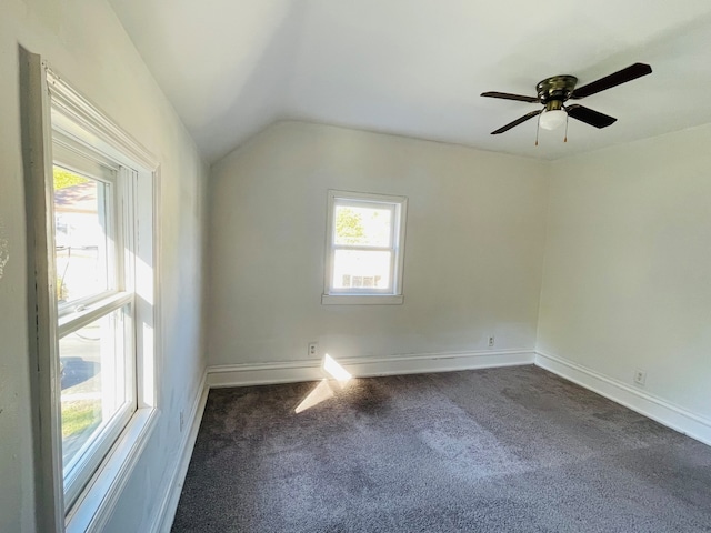 carpeted empty room with lofted ceiling, a healthy amount of sunlight, and ceiling fan