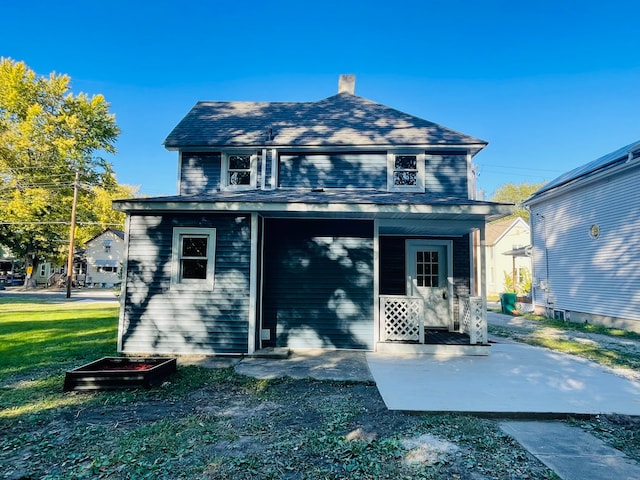 rear view of house featuring a yard and covered porch