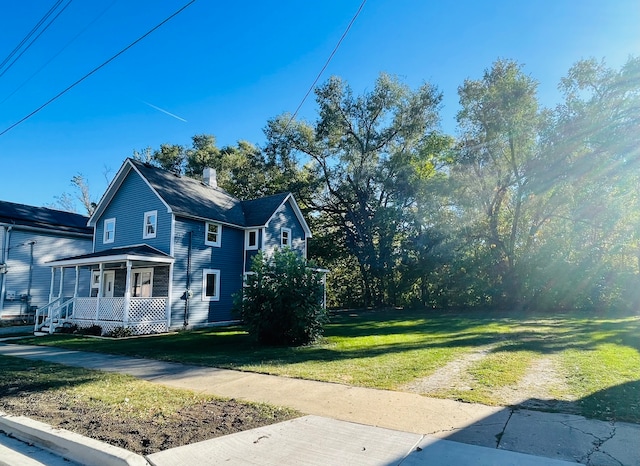 view of home's exterior with covered porch and a lawn