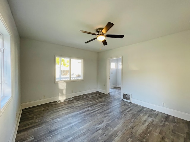 empty room with ceiling fan and dark hardwood / wood-style flooring