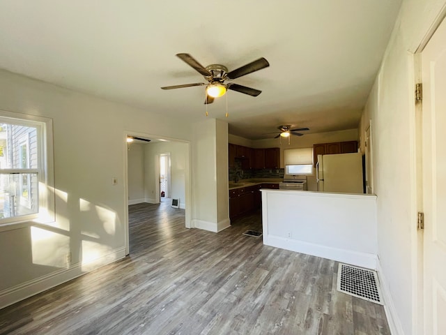 unfurnished living room featuring ceiling fan, hardwood / wood-style flooring, and sink