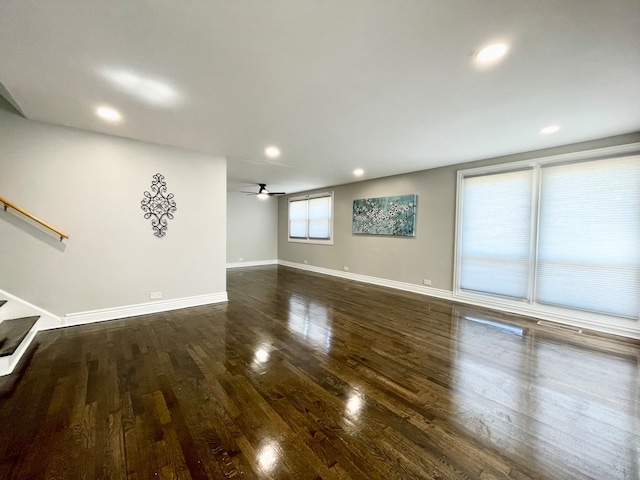 unfurnished living room with ceiling fan and dark hardwood / wood-style flooring