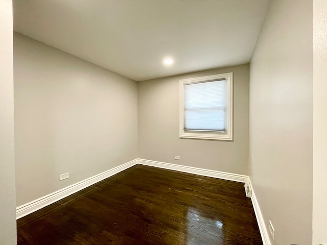 unfurnished room with dark wood-type flooring