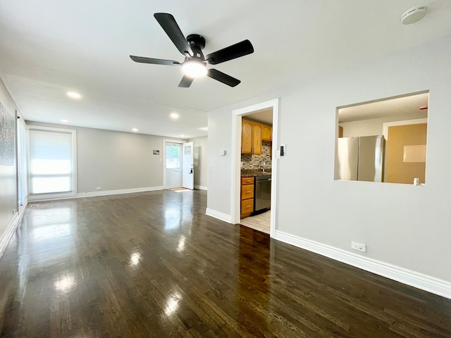 unfurnished living room featuring ceiling fan, dark hardwood / wood-style floors, and plenty of natural light