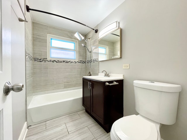 full bathroom featuring vanity, tiled shower / bath combo, and toilet