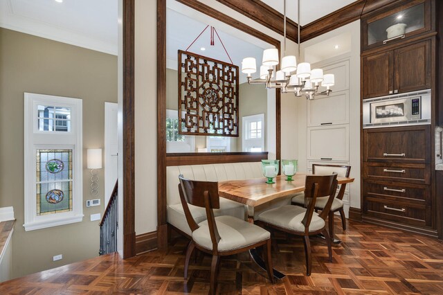 dining area featuring an inviting chandelier, dark parquet flooring, and a healthy amount of sunlight